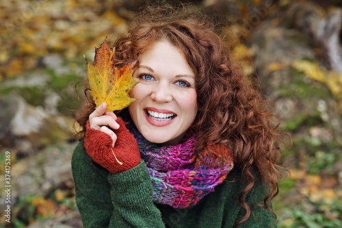 jeune et jolie femme rousse dans un parc arbor   en automne avec des feuilles mortes