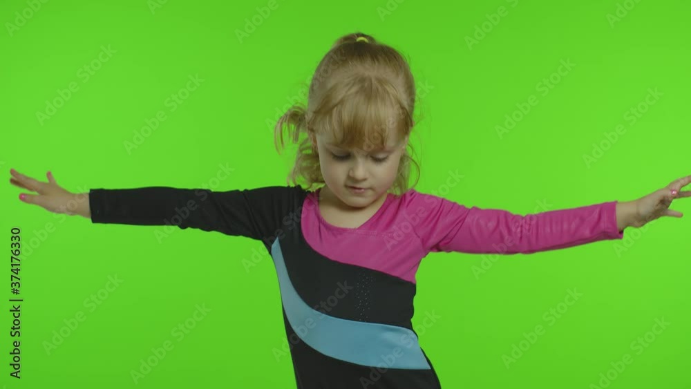 Child ballerina exercising in studio on chroma key background. Girl kid dancing, making gymnastics Child ballerina exercising in studio on chroma key background. Girl kid dancing, making gymnastics