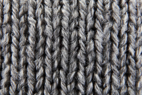 Grey ribbed knitted wool background texture macro with selective focus