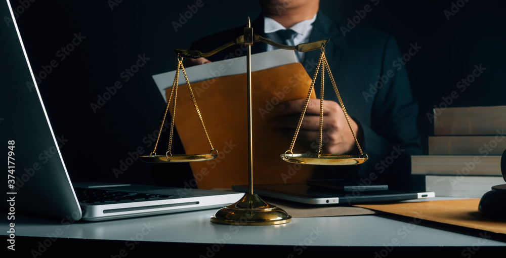 Fototapeta premium Business and lawyers discussing contract papers with brass scale on desk in office. Law, legal services, advice, justice and law concept picture with film grain effect