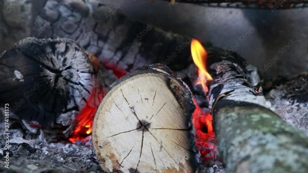 Panning right across a campfire in a pit ready for grilling showing flames and charcoal Panning right across a campfire in a pit ready for grilling showing flames and charcoal
