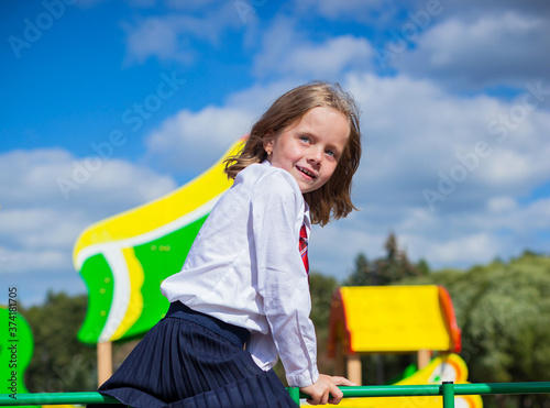 Cute schoolgirl playing on the Playground. Back to school.