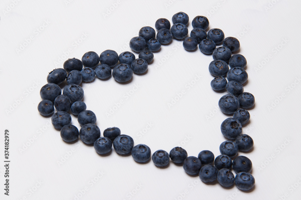 group of blueberries on white wooden background in form of heart group of blueberries on white wooden background in form of heart