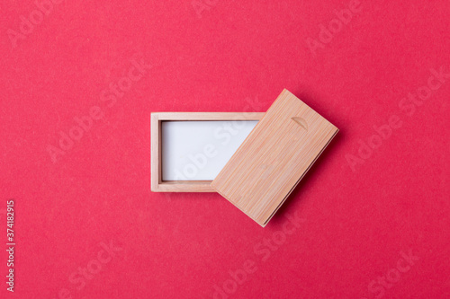 open wooden box with place for you logo on red colored paper background