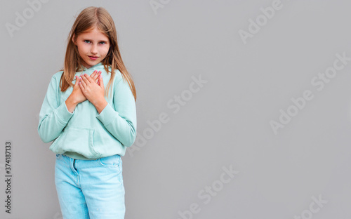 Woman's hands on her chest isolated on gray background