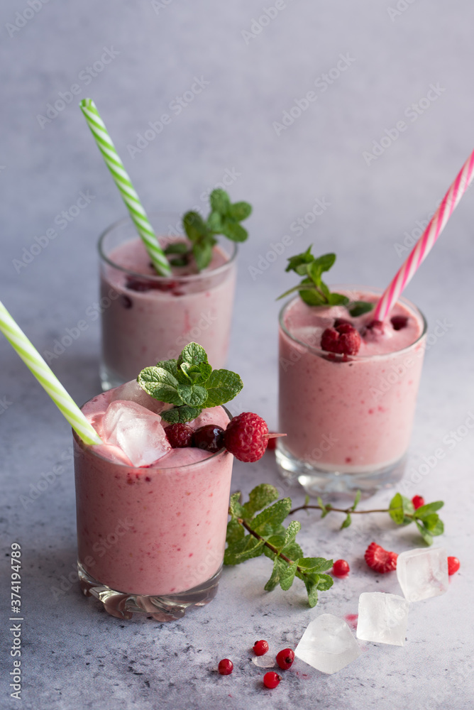 Glasses of berry smoothie with fresh mint on dark background. Glasses of berry smoothie with fresh mint on dark background.