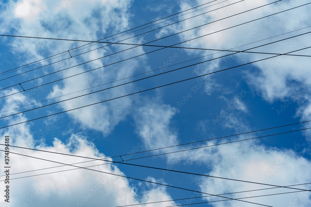 electric wires against blue sky and clouds electric wires against blue sky and clouds