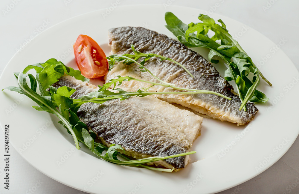 Sea bass fillet fried on a plate, seafood. Sea bass fillet fried on a plate, seafood.