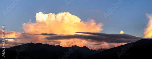 Storm clouds over the mountains. Cloudscape at sunset. Gewitterwolken über den Bergen. Wolkengebilde bei Sonnenuntergang. Panorama with mountain silhouette. © Lukas Bast