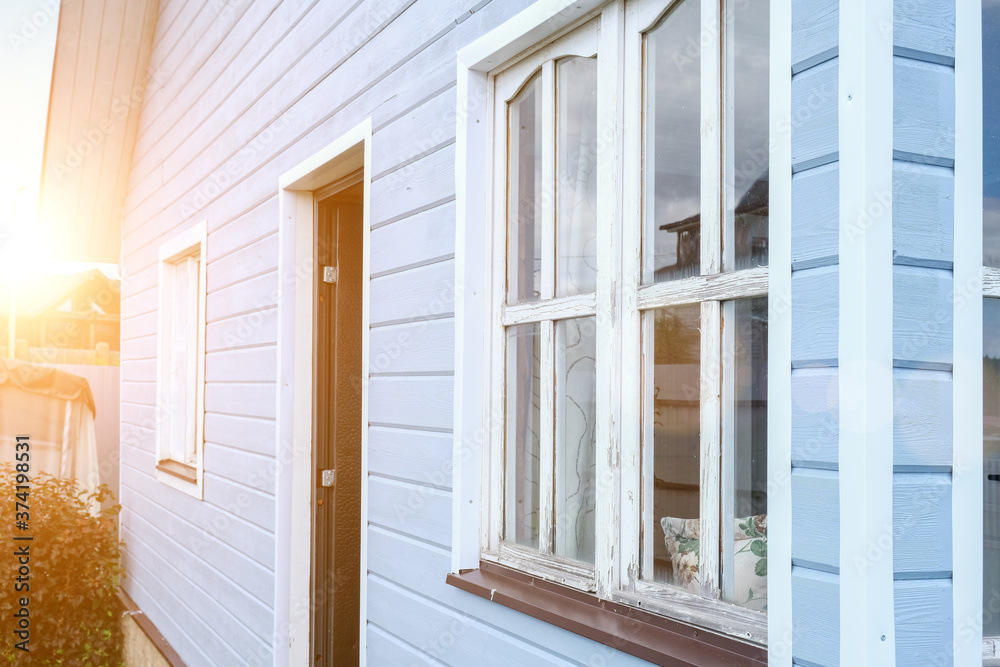 A front part of a modern scandinavian tiny wooden house painted in blue on summer day A front part of a modern scandinavian tiny wooden house painted in blue on summer day