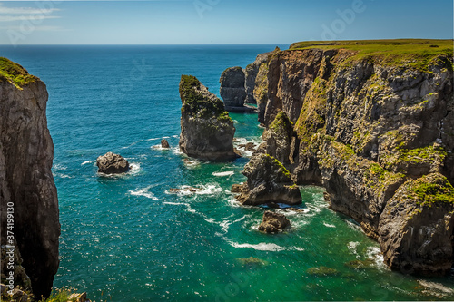 Rock stacks offshore viewed from the top of a secluded cove along the Pembrokeshire coast, Wales in summer photo