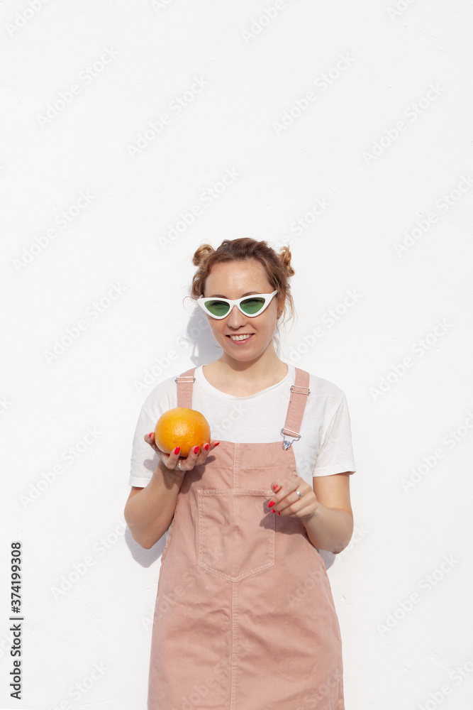 Studio portrait of happy girl, smiling cheerfully, holding ripe grapefruit in hands, standing isolated over white background. Tasty tropical fruit, healthy food, raw food diet Studio portrait of happy girl, smiling cheerfully, holding ripe grapefruit in hands, standing isolated over white background. Tasty tropical fruit, healthy food, raw food diet