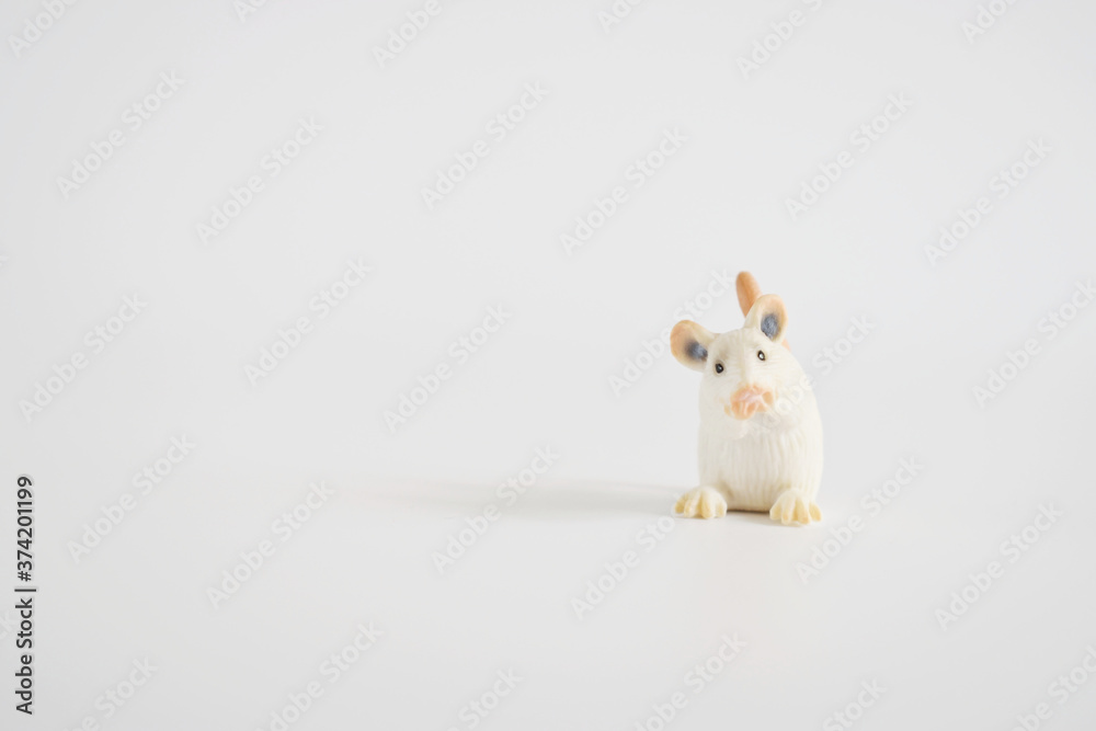 Fototapeta premium toy miniature white mouse, isolated plastic toy mouse on white background space for text