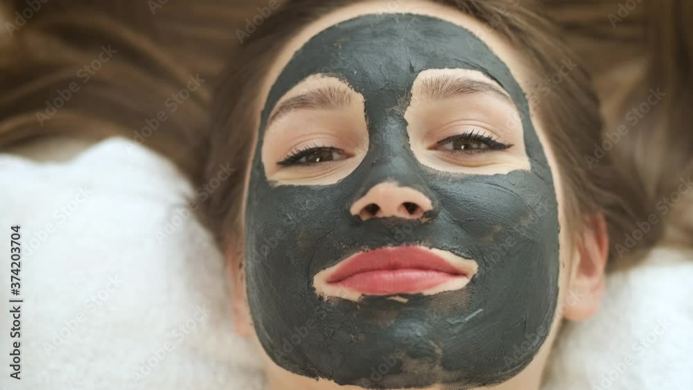 Woman lies on the table in a modern spa and relaxes. Applying a mask to rejuvenate the skin. Health and beauty Woman lies on the table in a modern spa and relaxes. Applying a mask to rejuvenate the skin. Health and beauty