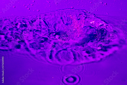 splash of water in lilac light. Abstract wallpaper