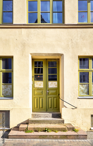 Light green wooden door and window as an entrance in an old house.