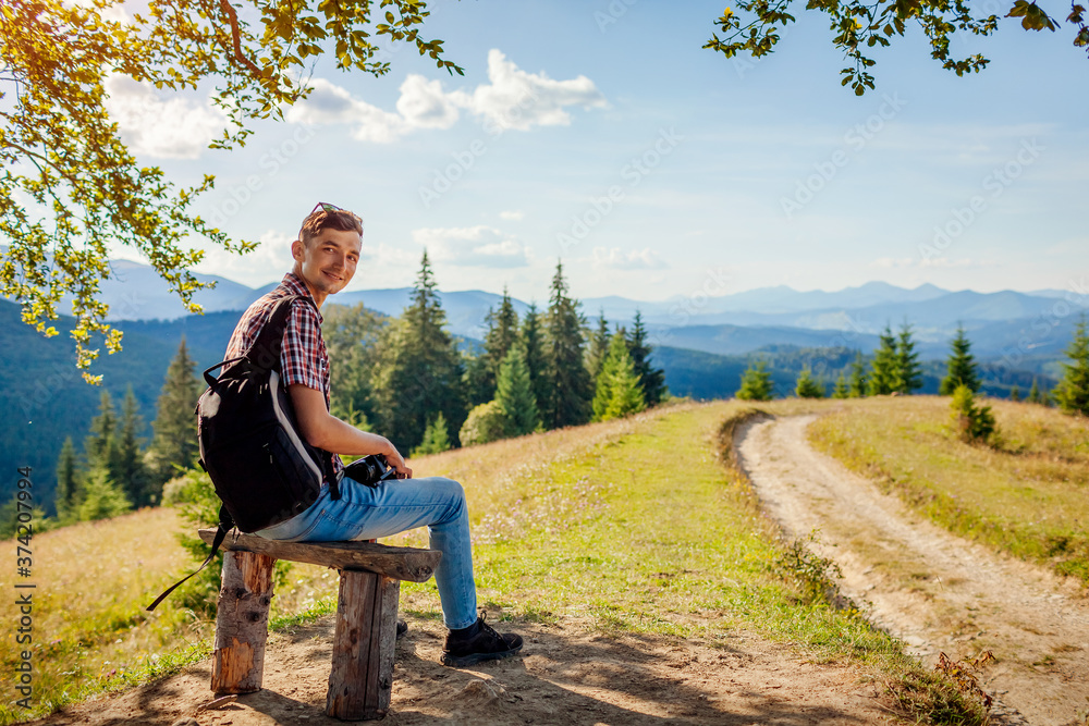 Man traveler hiker resting sitting under tree. Trip to Carpathian mountains. Tourism in summer Ukraine. Man traveler hiker resting sitting under tree. Trip to Carpathian mountains. Tourism in summer Ukraine.