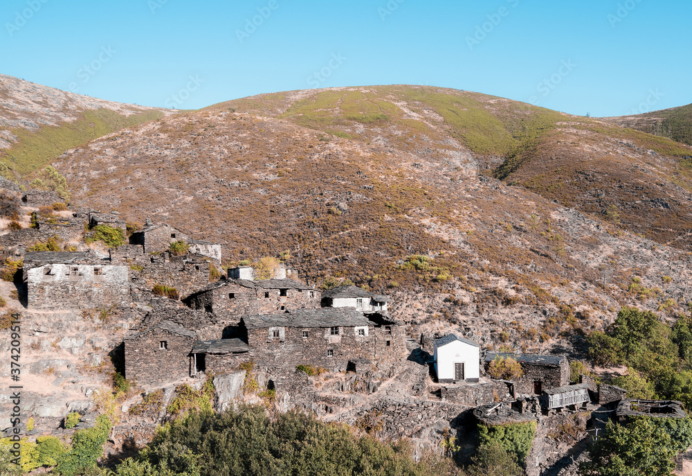 Stone houses on a hill in Drave, an abandoned village in Portugal.