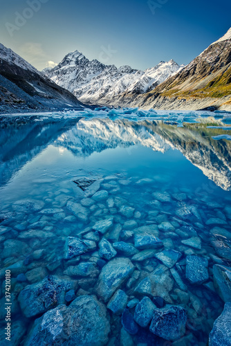Hooker lake with snow capped Mount Cook in the distance reflecting in the lake and a beautiful clear blue sky photo