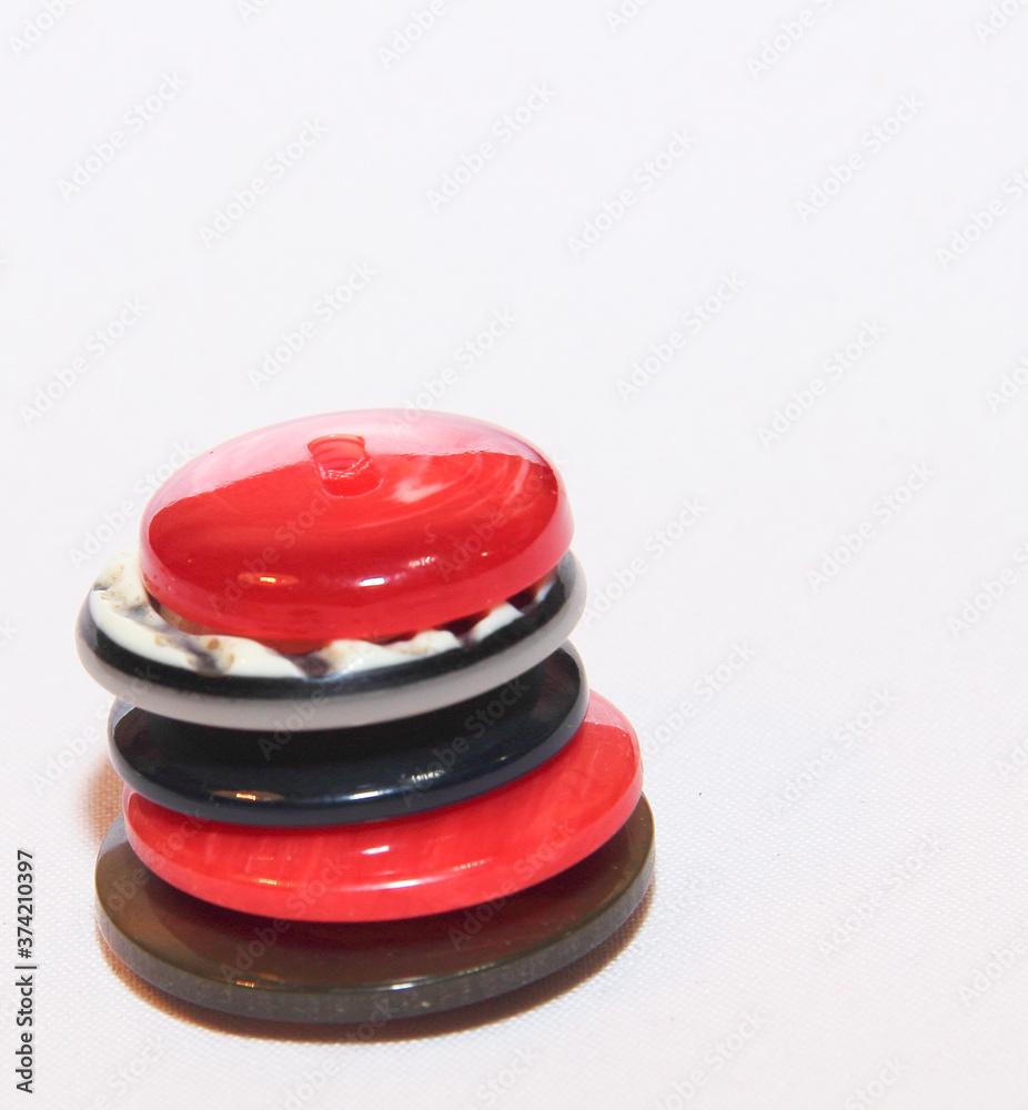 Three buttons on a light background, different in color. Sewing accessories for clothing decoration. Three buttons on a light background, different in color. Sewing accessories for clothing decoration.
