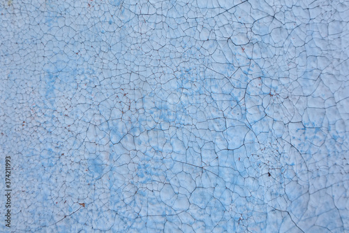 Texture of weathered and cracked blue paint on old wooden surface.