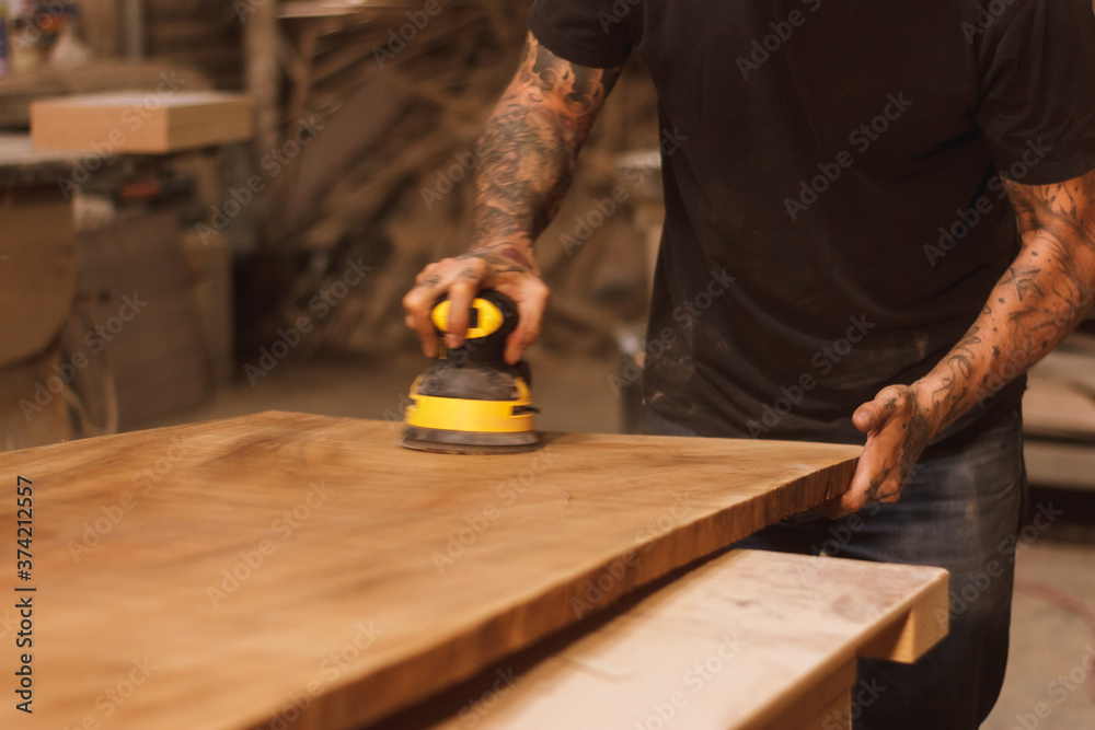 Mano de Carpintero mexicano artesano con tabla de madera lijando