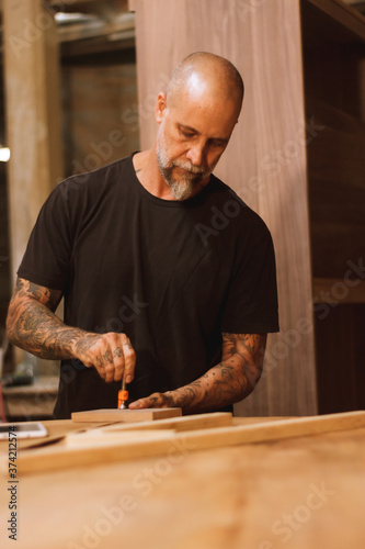 Carpintero mexicano artesano con tabla de madera y pinzas