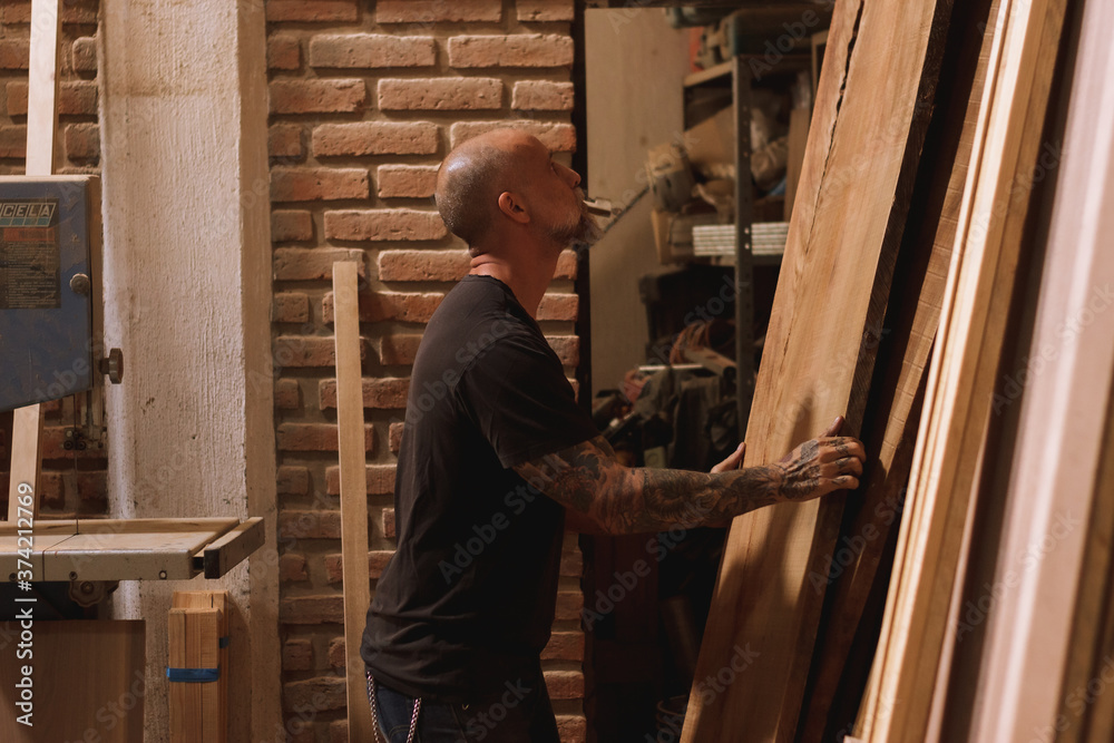 Hombre mexicano maduro carpintero en taller con madera trabajando