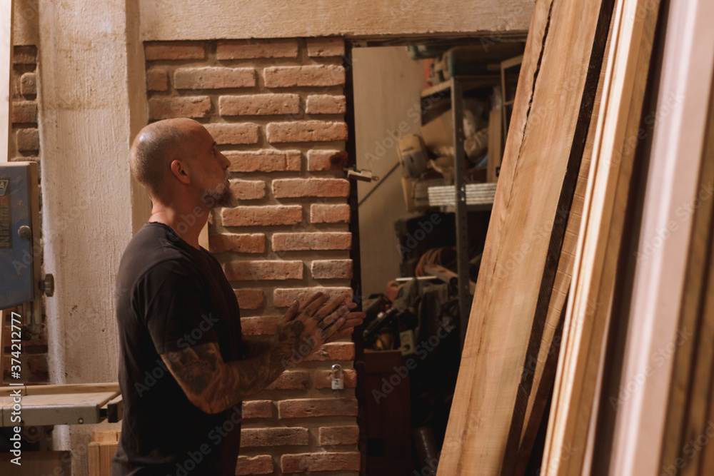Hombre mexicano maduro carpintero en taller con madera trabajando Hombre mexicano maduro carpintero en taller con madera trabajando