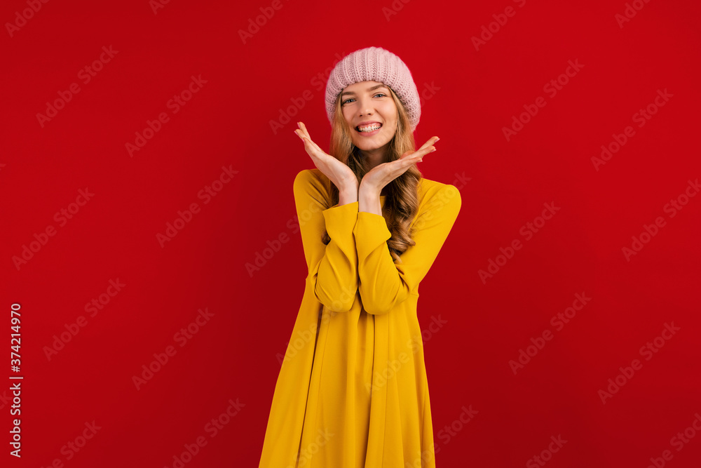 Happy beautiful young woman in a warm hat on her head, on a red background Happy beautiful young woman in a warm hat on her head, on a red background