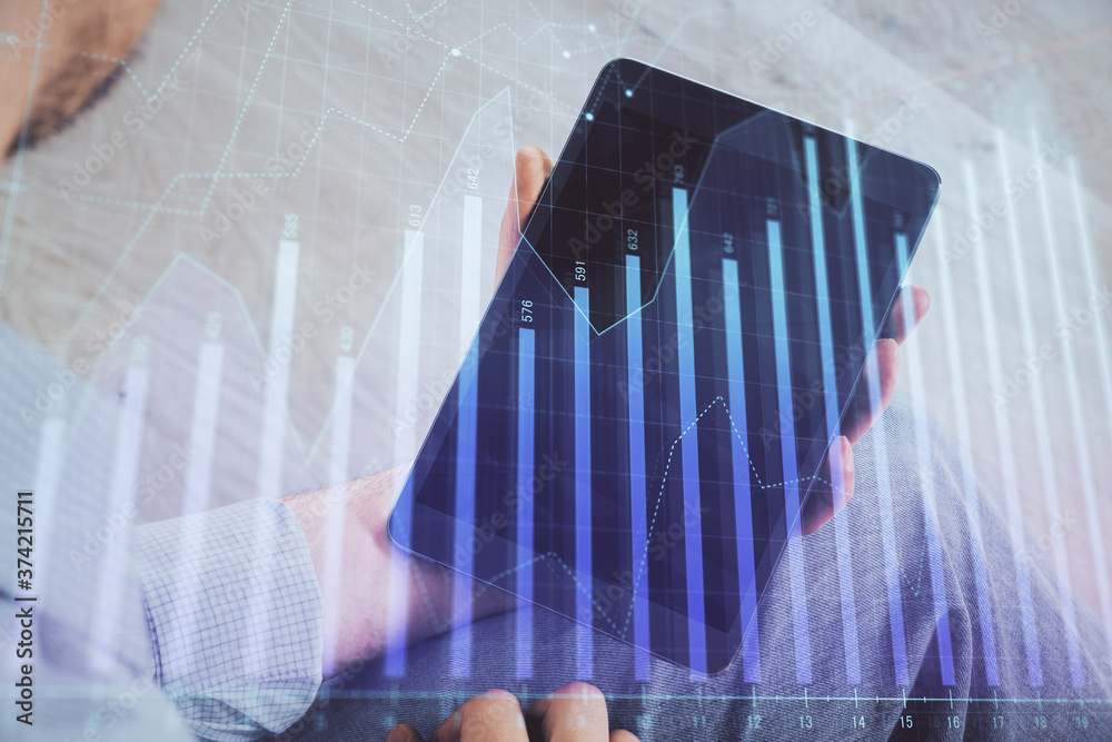 Double exposure of man's hands holding and using a digital device and forex graph drawing. Financial market concept. Double exposure of man's hands holding and using a digital device and forex graph drawing. Financial market concept.