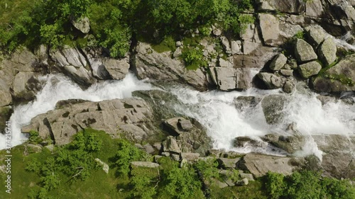 Freshwater stream flows down a rocky landscape in the Norwegian countryside. Aerial top down view.  photo