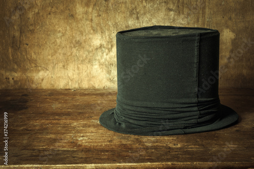 Obraz na plátně Retro black hat on a wooden table