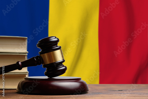 Justice and court concept in Romania. Judge hammer on a flag background