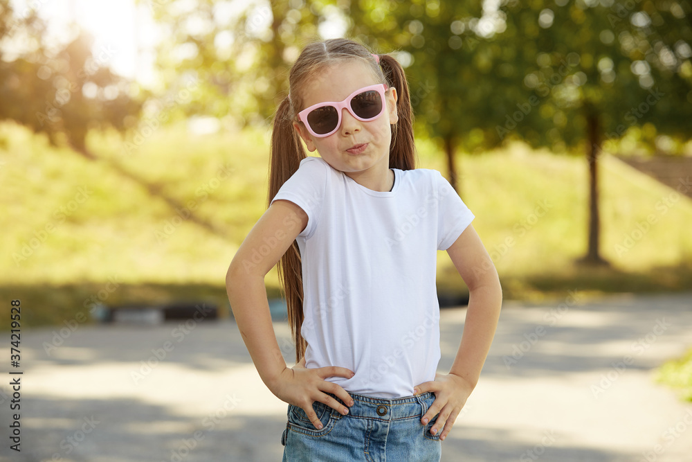 smiling girl in a city Park on a warm Sunny day wearing sunglasses smiling girl in a city Park on a warm Sunny day wearing sunglasses