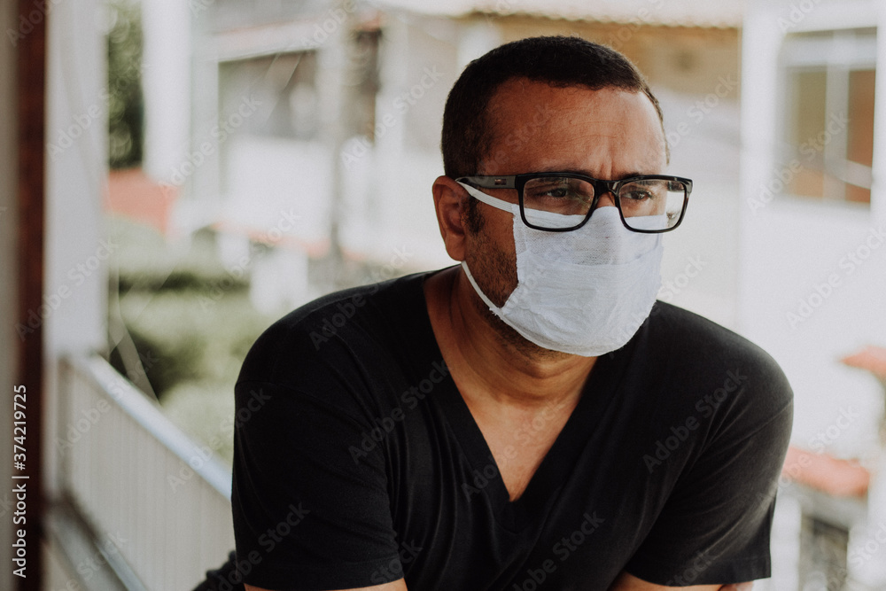 Sick brazilian man wearing medical mask at home during Coronavirus outbreak Sick brazilian man wearing medical mask at home during Coronavirus outbreak