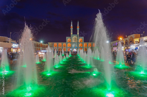 Iran, in the city of Yazd, The Complexe Amir Chaghmagh, the mosque at night illuminated by colourful lights. photo