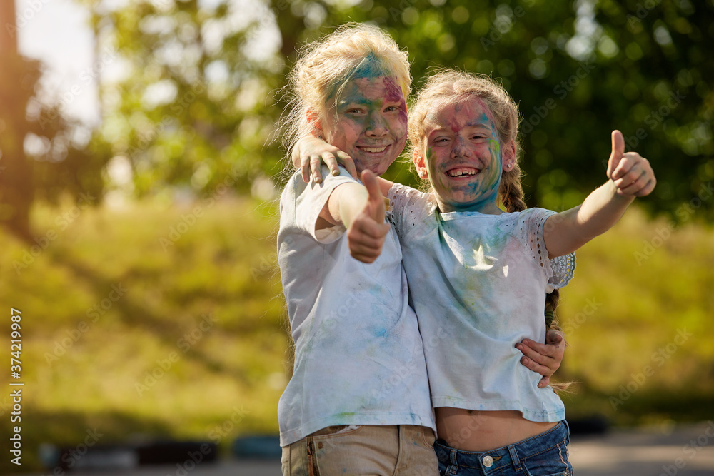 Fototapeta premium Two sisters pose for the camera outdoors in a Sunny Park. Selective focus