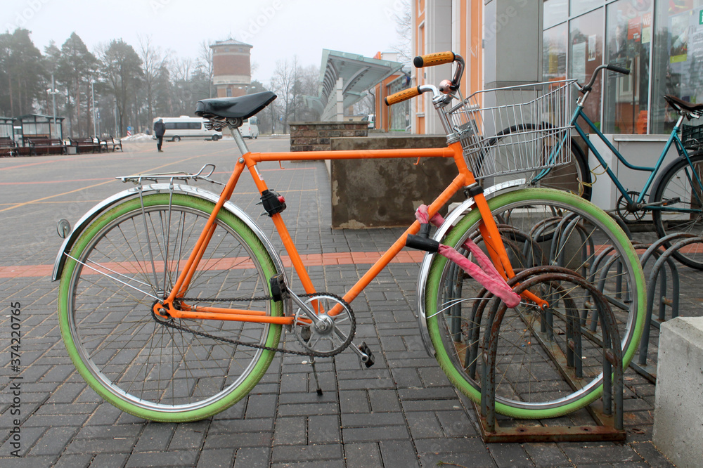 Colorfull hipster bike parked near a railway station in a cold cloudy day