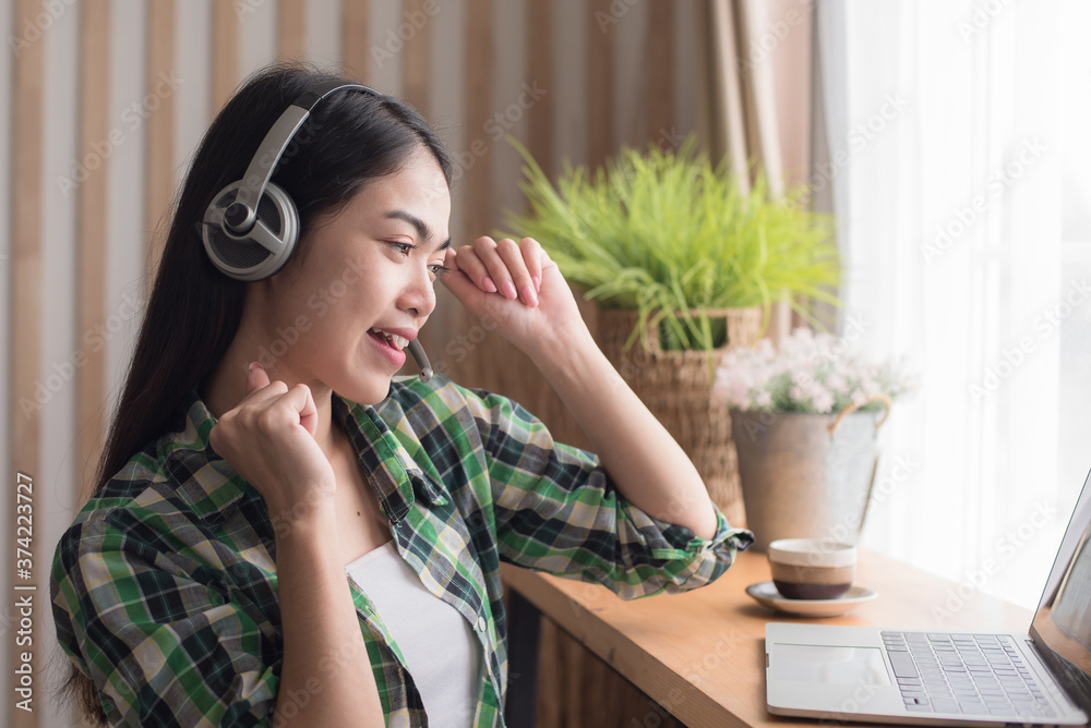 Beautiful young woman in casual clothing using mobile and smiling while working indoors Beautiful young woman in casual clothing using mobile and smiling while working indoors
