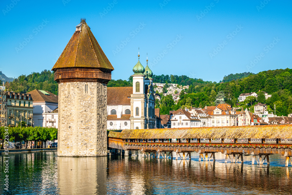 View of Chapel bridge or Kapellbrucke with tower and Jesuit church with clear blue sky Lucerne old town Switzerland View of Chapel bridge or Kapellbrucke with tower and Jesuit church with clear blue sky Lucerne old town Switzerland
