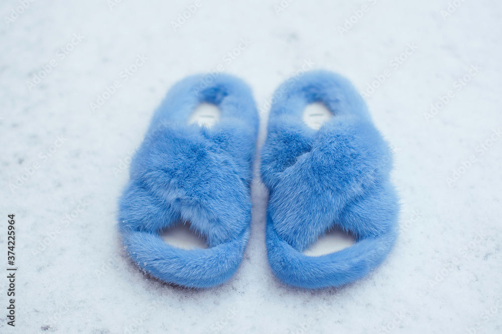 Fashionable blue female fur sandals on the snow. Outdoor street style. Fashionable blue female fur sandals on the snow. Outdoor street style.