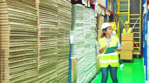 Diversity group of workers (Asian, Caucasian, Black) work in warehouse