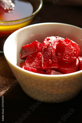 Sliced, spice pickled beetroot in mosaic pattern white bowl