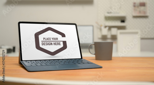 Mock up digital tablet with keyboard, coffee mug and copy space on wooden table