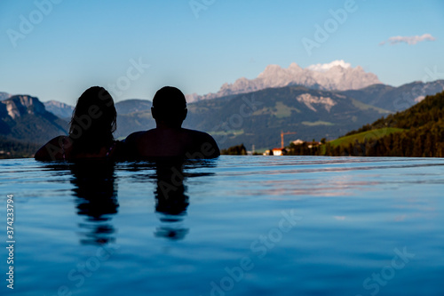 couple looks to the mountain out of an infinity pool