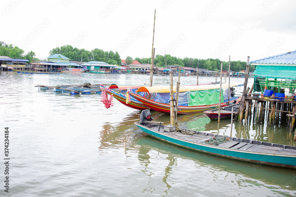 Long-tailed boats are on the waterfront in a fishing village