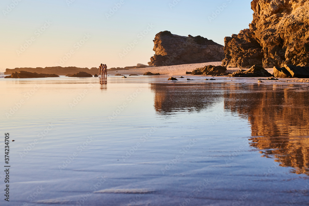 Low tide beach with reflection of the cliffs on the water.