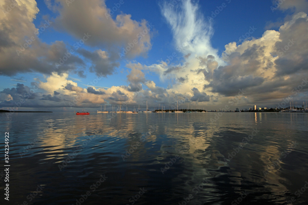 Summer cloudscape over moored sailboats in Crandon Marina on Key Biscayne, Florida in early morning light.