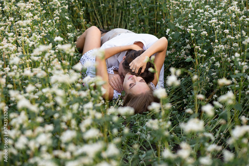 Fotografi couple embracing lying in the grass on the meadow